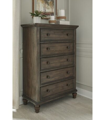 Dark brown wood five-drawer chest with bun feet in a bedroom setting