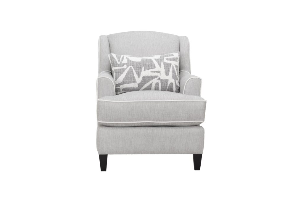 Light grey fabric sofa chair with white piping and geometric scatter cushion