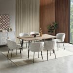 Rectangular wood-look dining table with six ivory boucle chairs and black metal legs