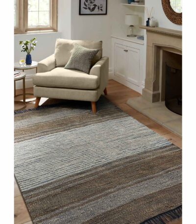 Handwoven cotton dhurry rug in neutral stripes with fringed edge in a living room