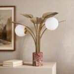 Gold metal table lamp with leaf details, marble base, and two frosted glass globe shades