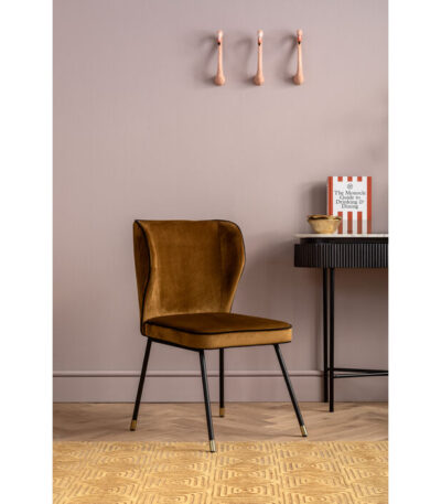 Mustard yellow velvet dining chair with wingback design and black steel legs