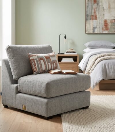 Warm grey fabric armless chair with deep seat and geometric scatter cushion