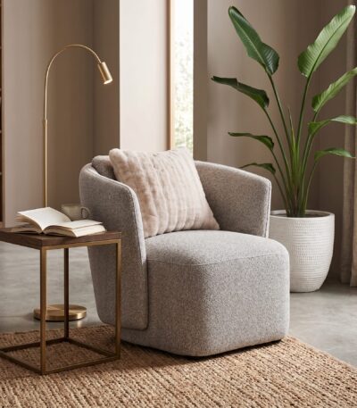 Warm grey textured fabric sofa chair with rounded barrel arms and blush scatter cushion